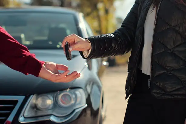 Customer receiving car keys at dealership.
