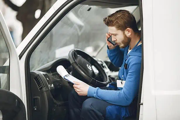 Delivery driver planning route in truck cabin.