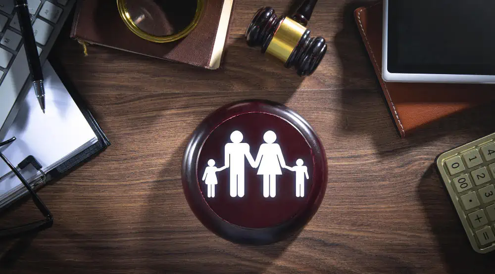Family planning icon with parents and children on a wooden desk.