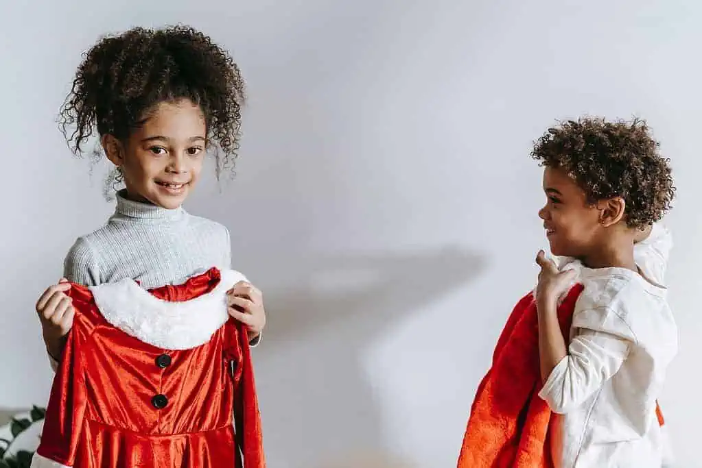 Happy black children with Santa Claus costumes

