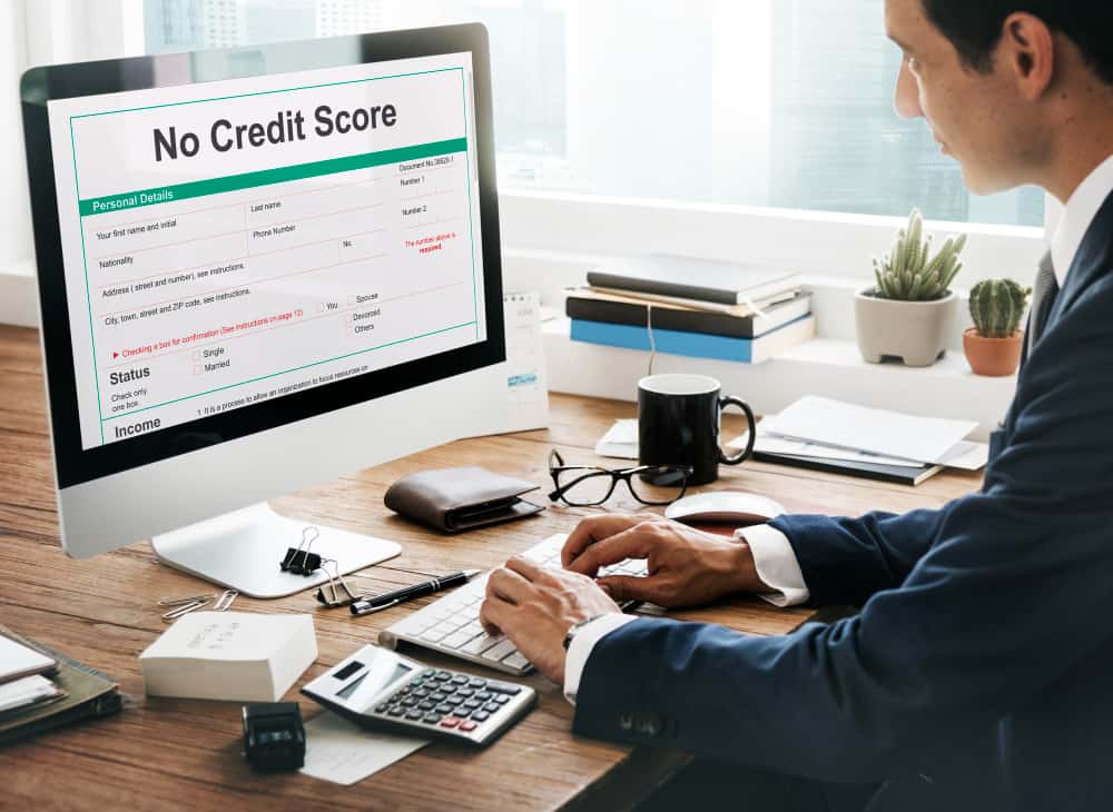 Home Icy 40 Man checking credit report on computer with "No Credit Score" message.