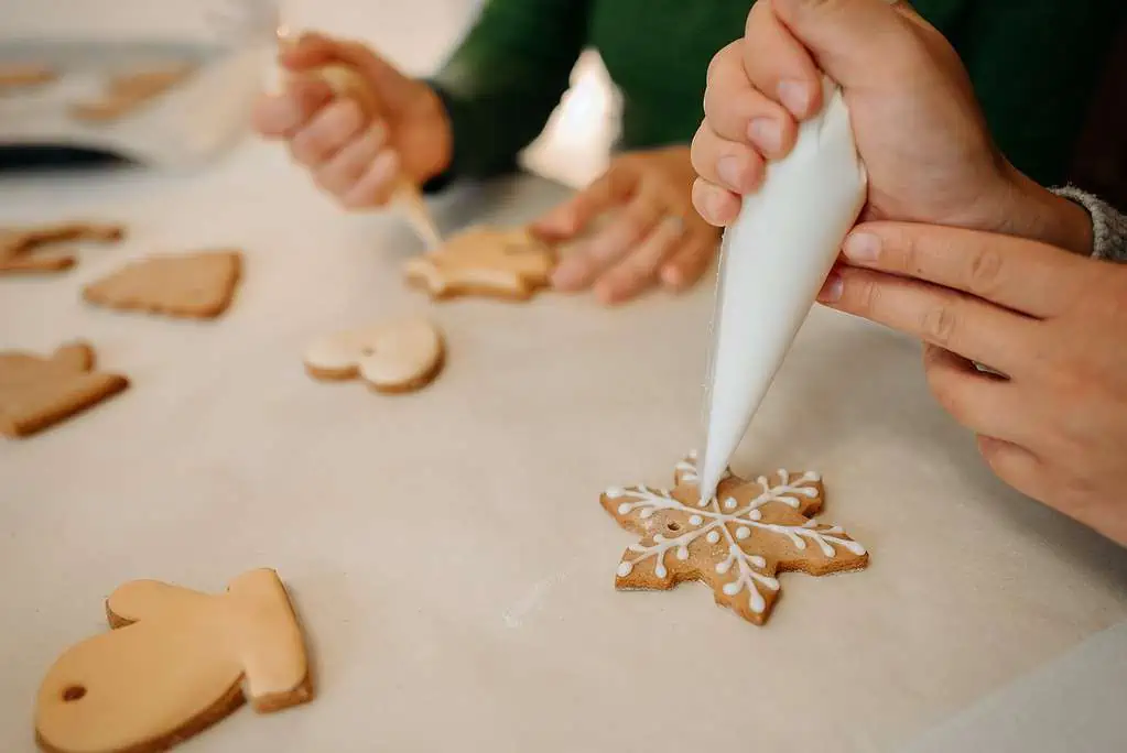 Person Putting Icing On A Christmas Cookie
