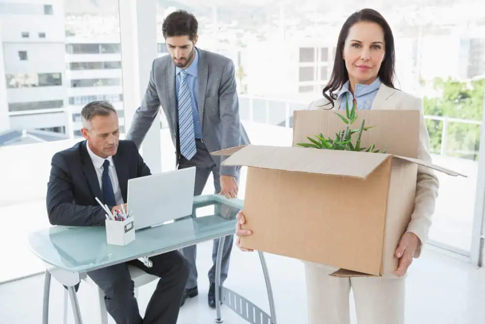 Businesswoman with box leaving office after job termination