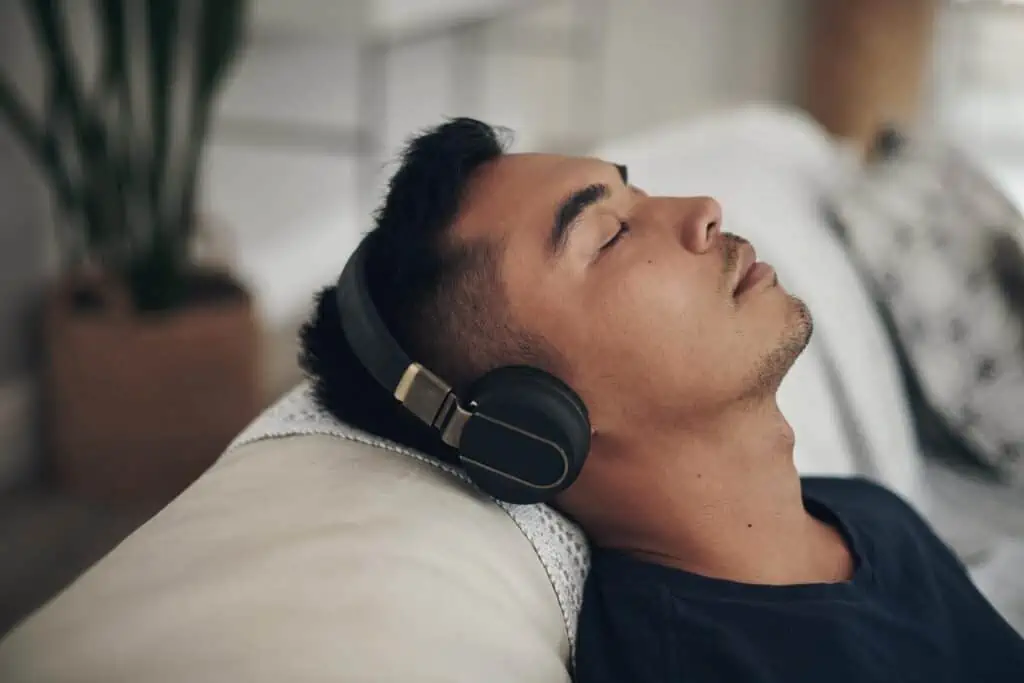 15 Ways to Keep Yourself Entertained on Your Mobile Phone When You're Bored 5 Shot of a young man using headphones at home.