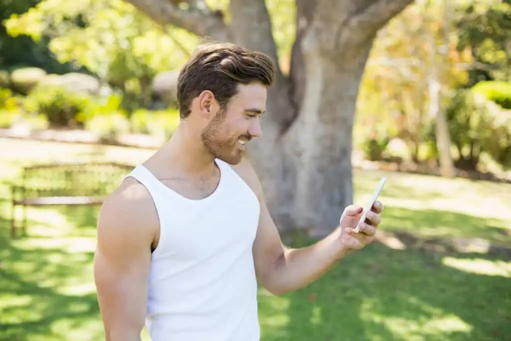 15 Ways to Keep Yourself Entertained on Your Mobile Phone When You're Bored 7 Man using mobile phone in park