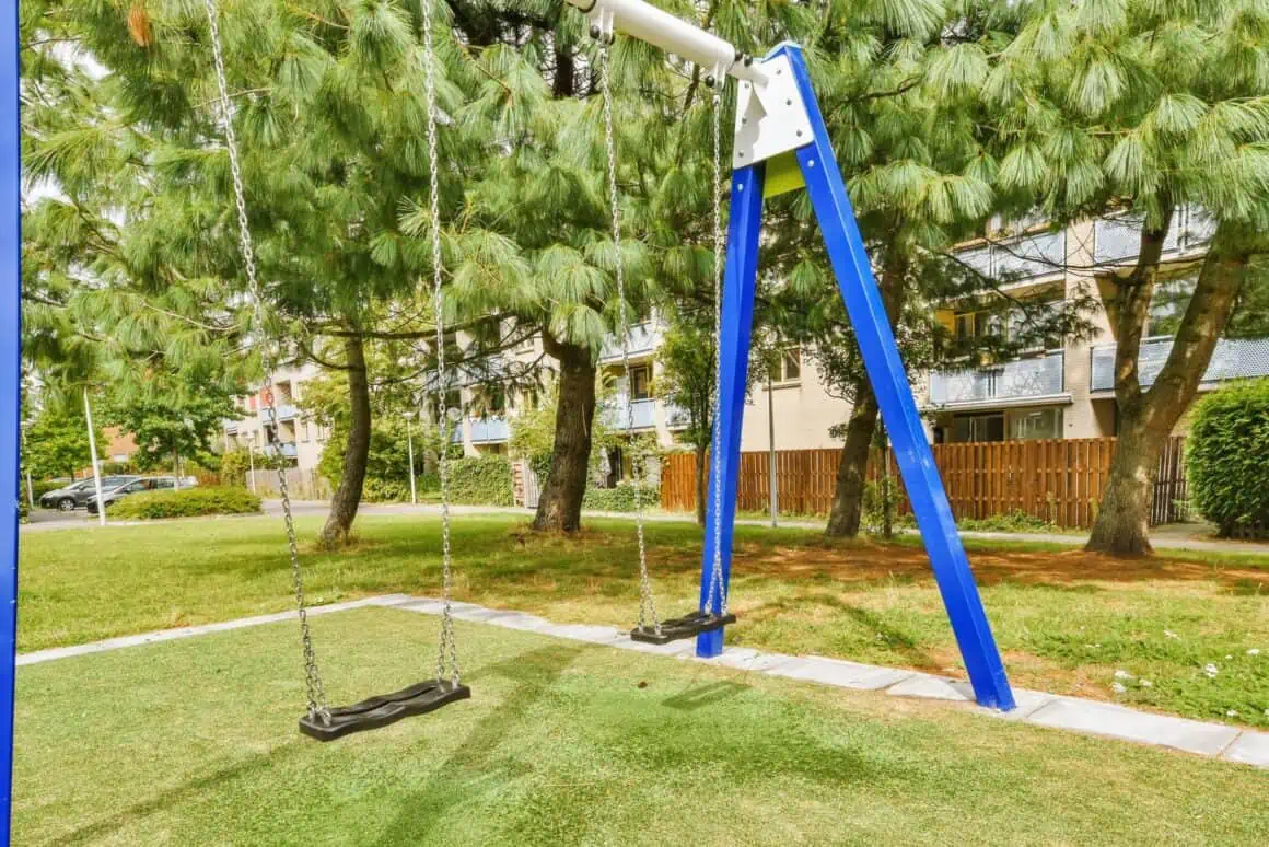 Playground swing set with two seats in a peaceful outdoor setting.