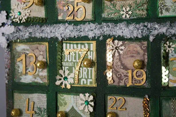 Advent calendar with numbered doors, holiday ornaments, and snow-themed decorations for Christmas.