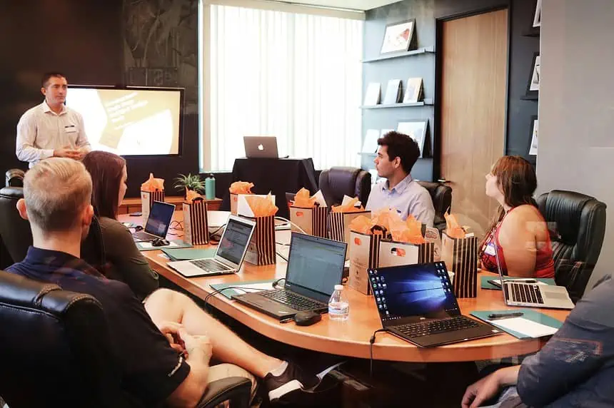 4 Workplace Personality Types for Creating Successful Business 1 Team meeting in a modern conference room with laptops and a presenter.