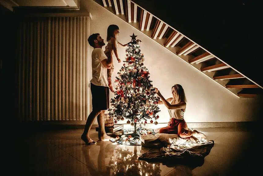 10 Captivating European Traditions Of Christmas 1 Family decorating a Christmas tree together at home.