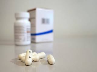 Prescription medication pills and bottles on a neutral background.