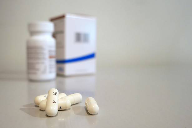 Prescription medication pills and bottles on a neutral background.