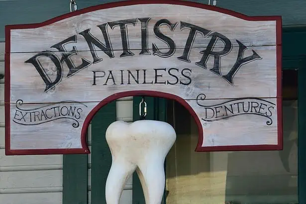Painless dentistry sign with a tooth-shaped ornament for dental clinic.