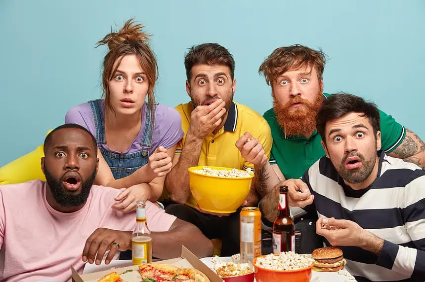 Binge-Worthy TV Shows I Discovered Through Reddit Recommendations 1 Group of friends watching sports game with snacks and drinks at home.