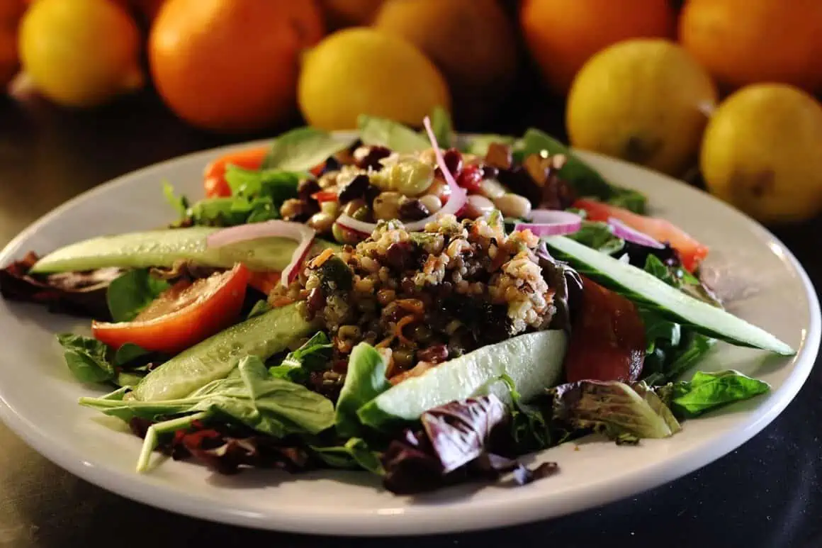 Colorful vegetable salad with quinoa, cucumbers, tomatoes, and leafy greens.