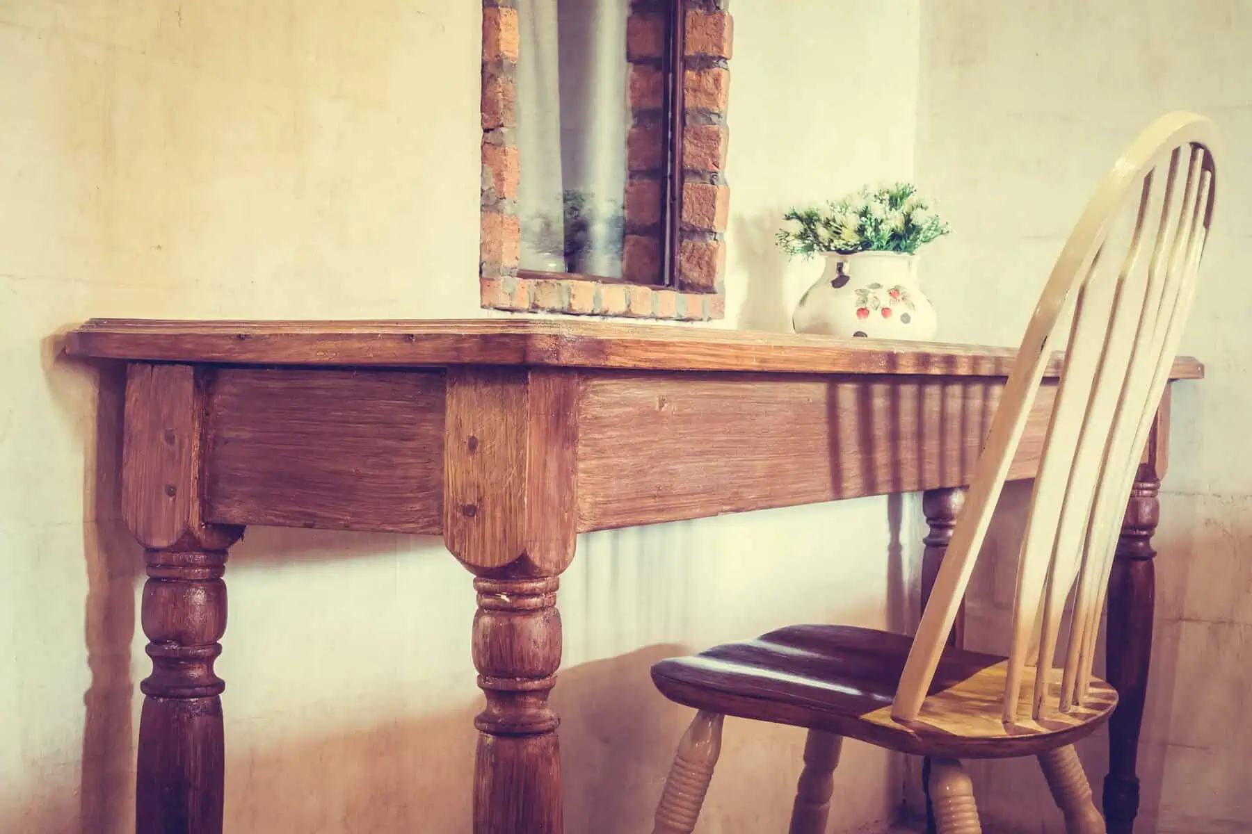 A rustic wooden table with a matching chair in a warm, inviting room.