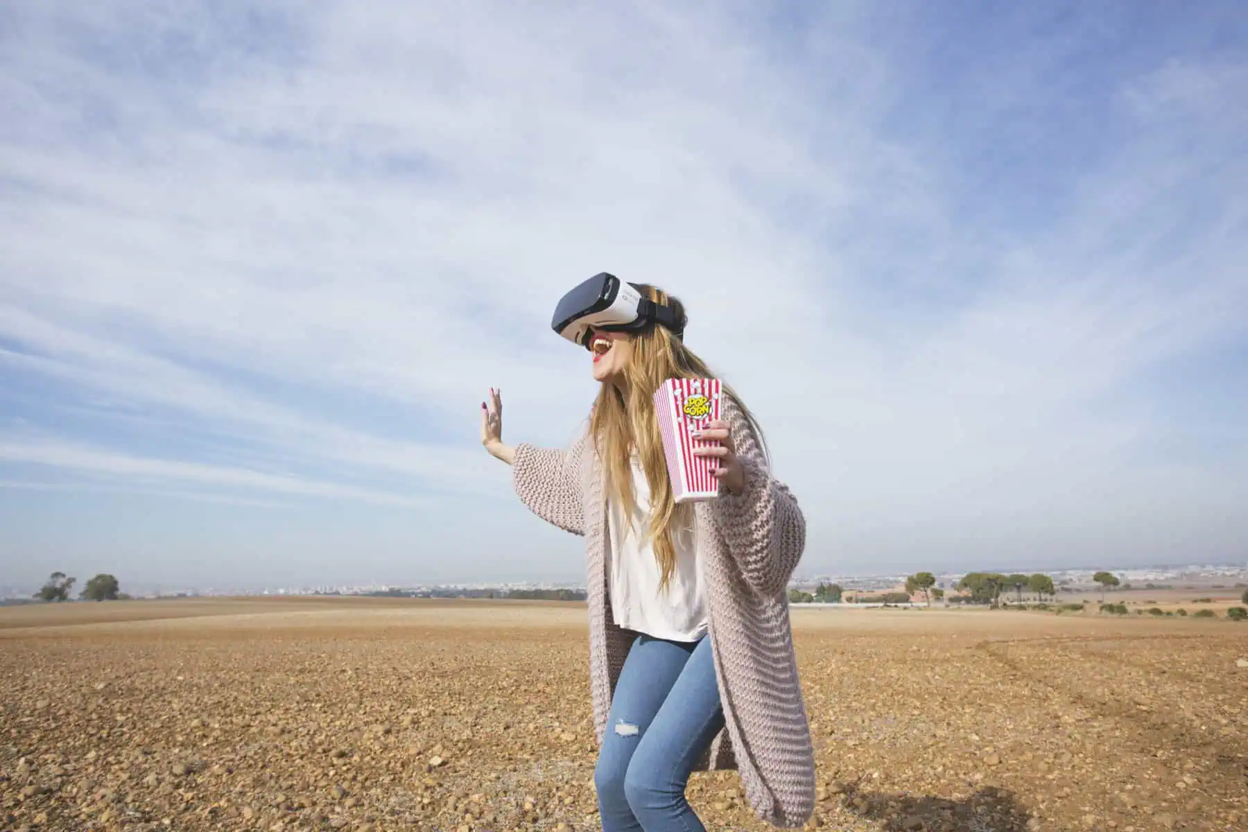 Virtual reality user experiencing immersive technology in open field.
