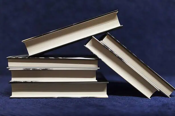 Stack of five books arranged on a dark background.