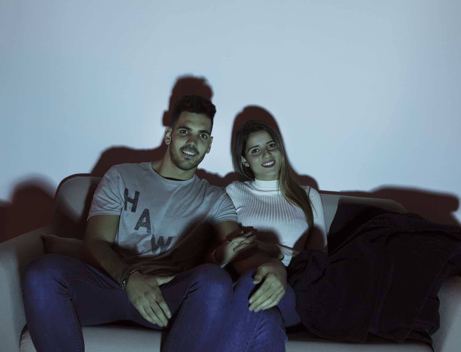 Enjoying a movie night with friends at home, relaxing on the sofa.
