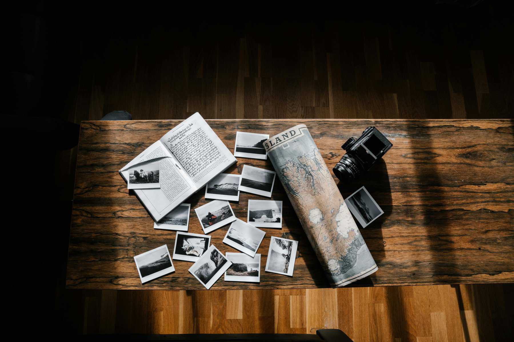 Home Icy 42 Vintage camera and scattered travel photos on wooden table.
