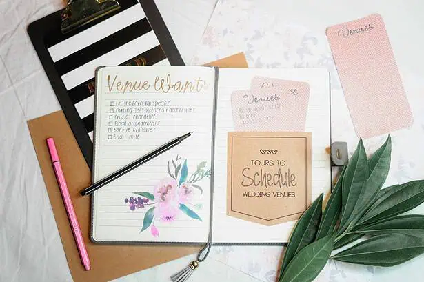 Wedding planning notebook with notes on venue options and schedule details.