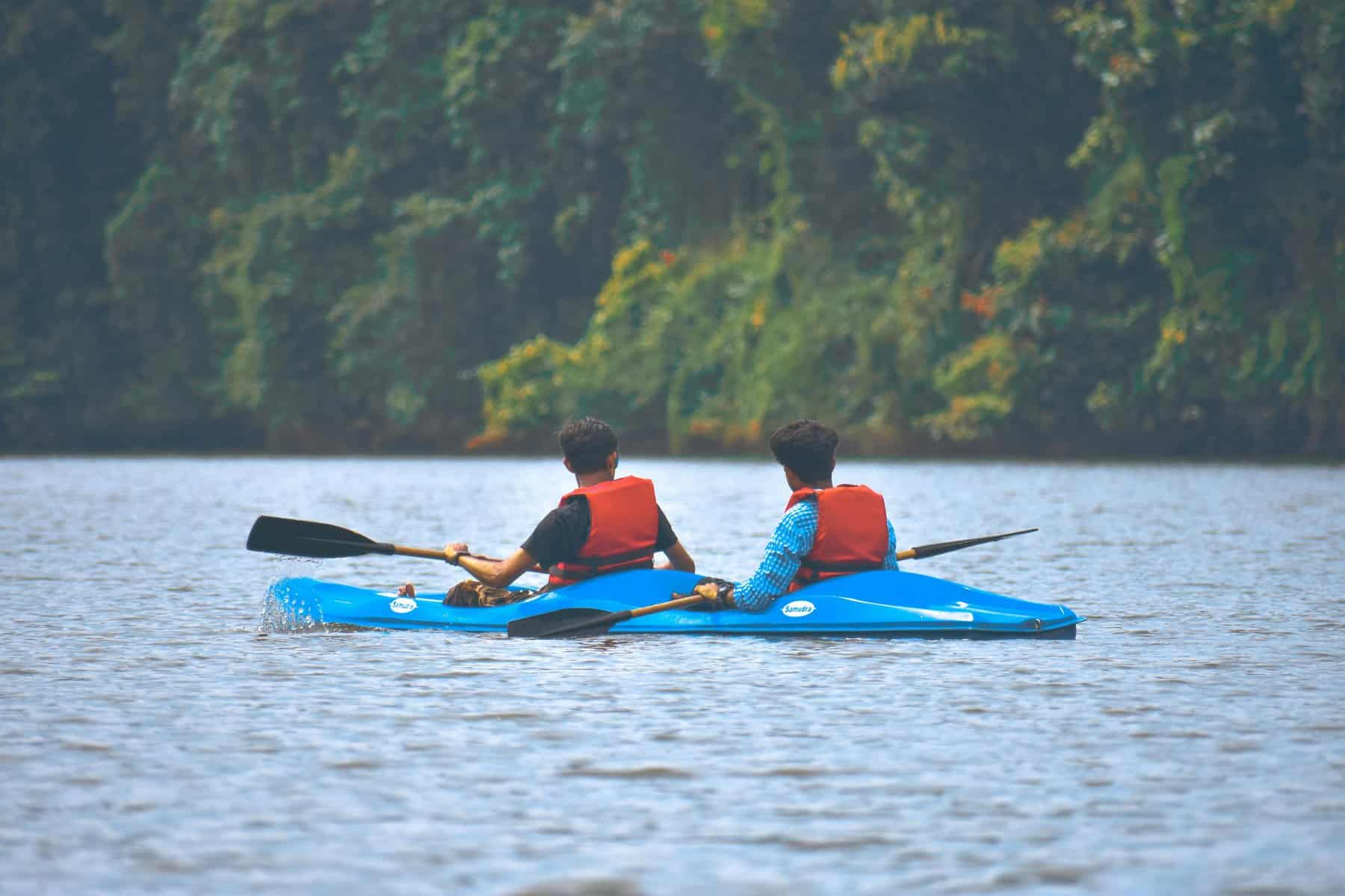 Kayaking with two people on a peaceful river surrounded by lush greenery.