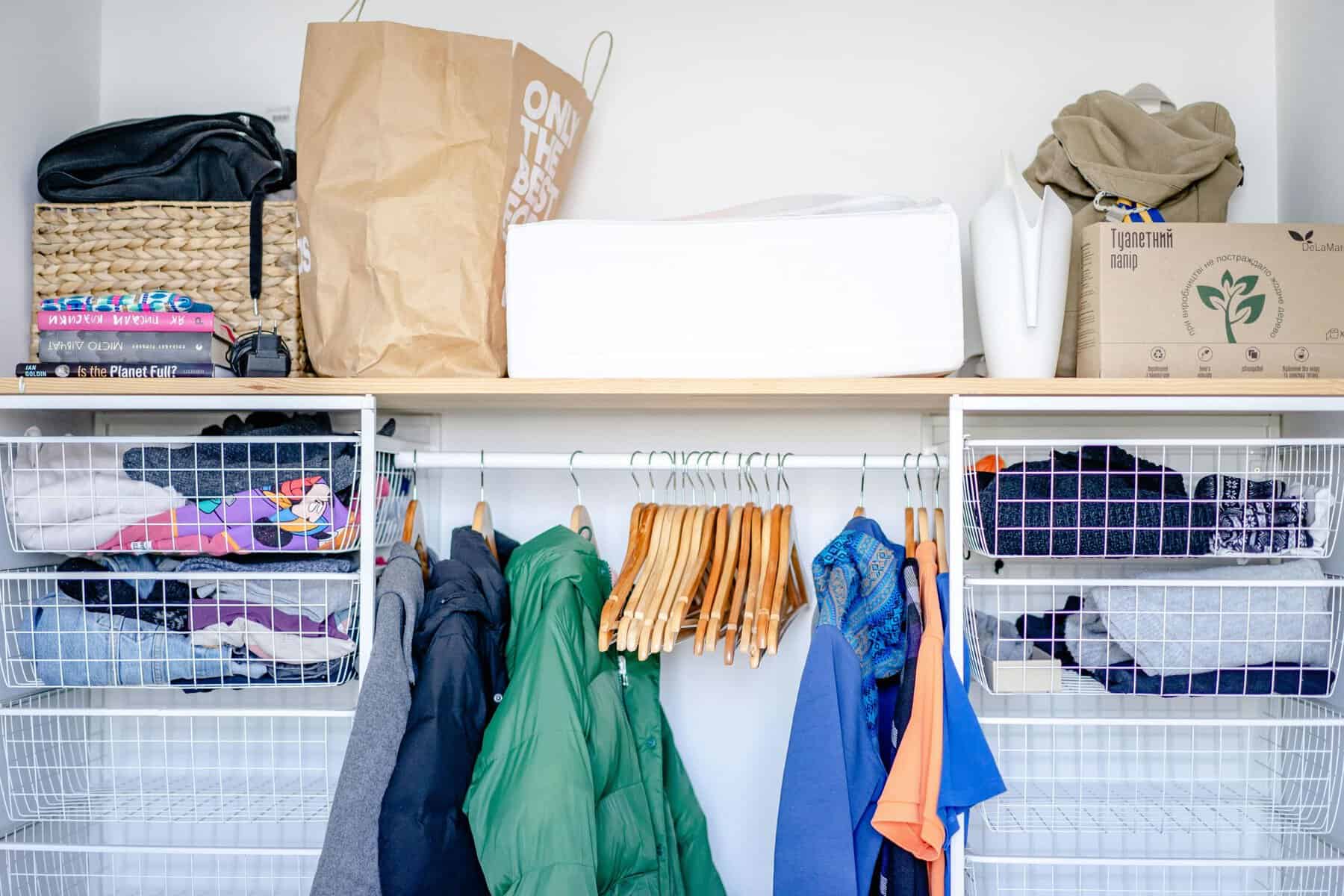 Home Icy 48 Efficient closet with hanging clothes and storage baskets for organized wardrobe.