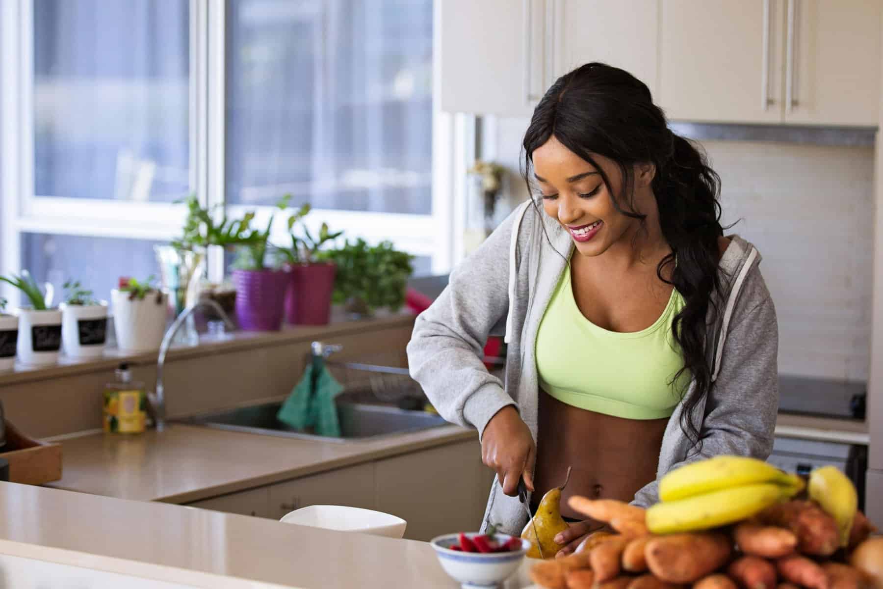 Home Icy 48 Healthy woman preparing a smoothie with bananas and sweet potatoes in a modern kitchen.