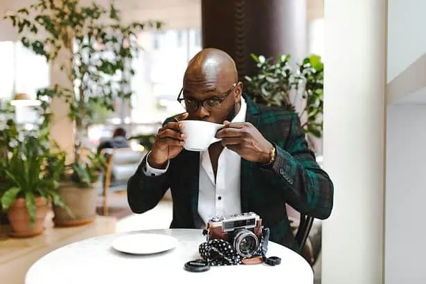 Enjoy a rich coffee in a stylish cafe setting with natural light and greenery.