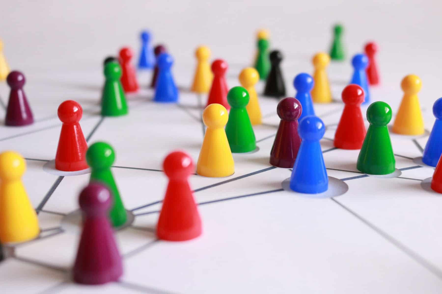 Colorful game pieces representing teamwork and strategic planning on a white surface.