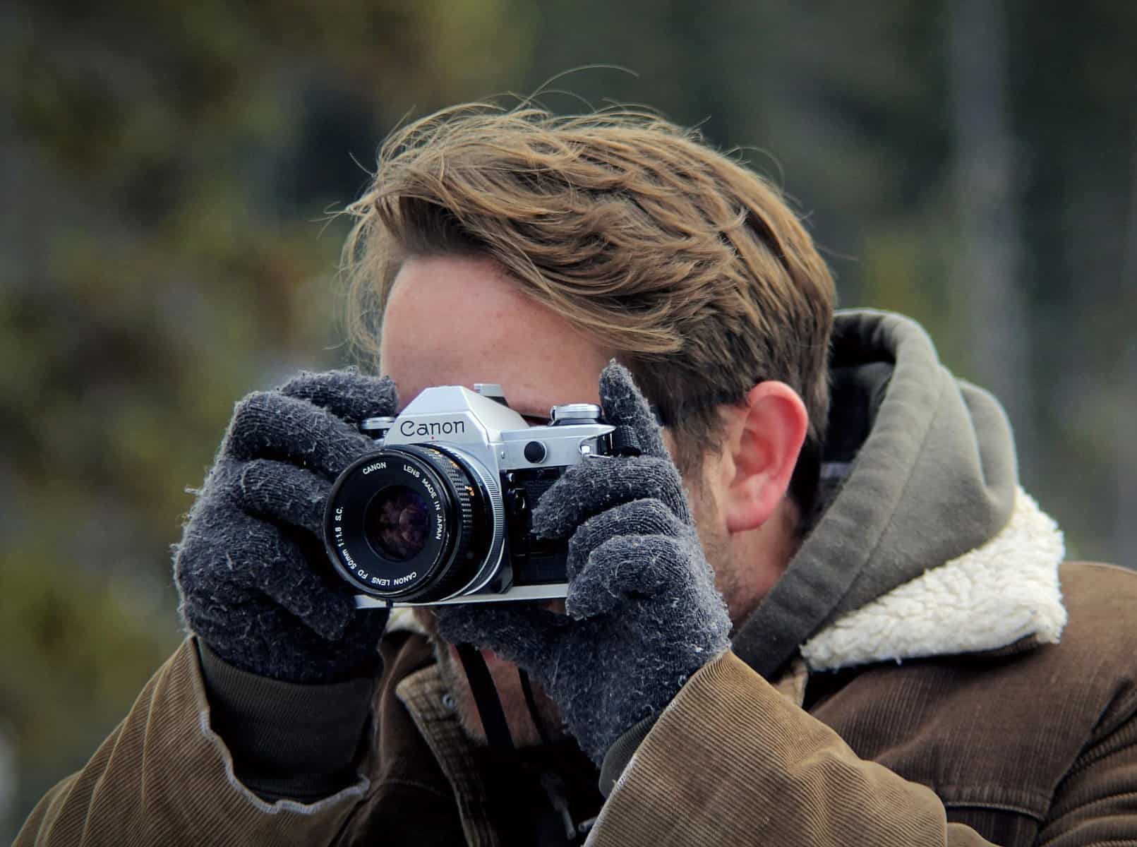 Home Icy 45 Photographer taking a photo outdoors with a Canon camera in a natural setting.