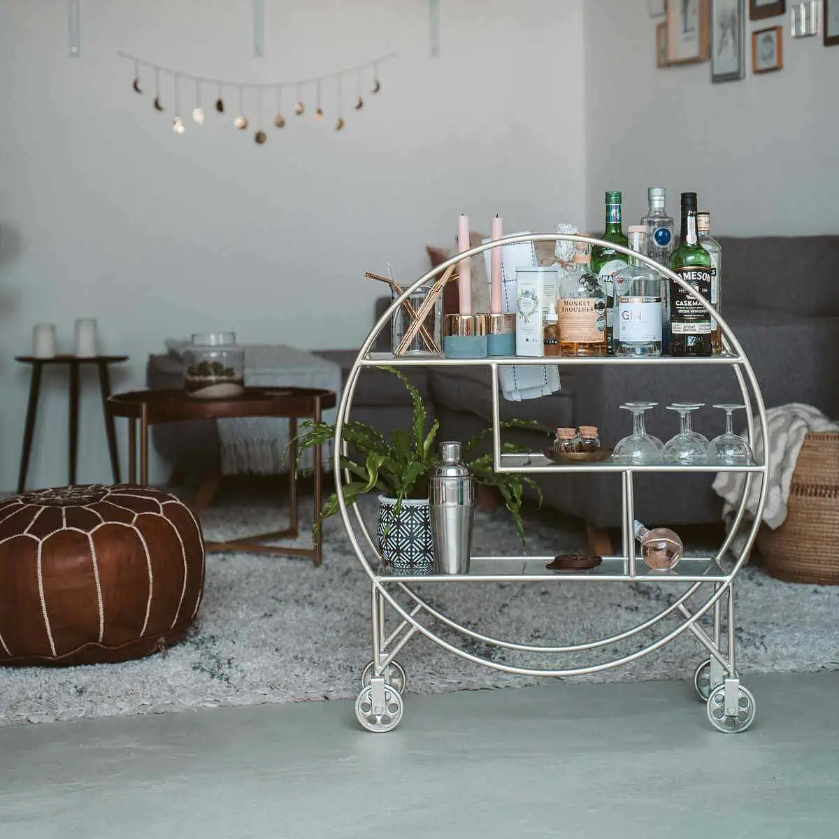 Stylish bar cart featuring bottles, glasses, and bar accessories in a modern living room setting.