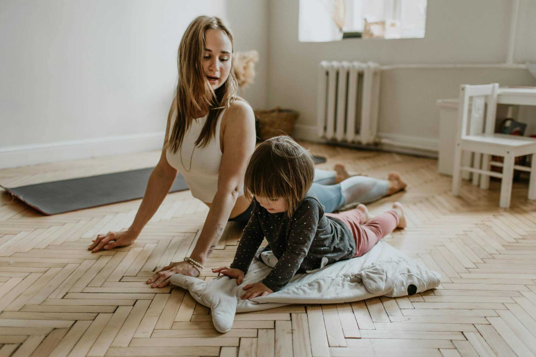 Home Icy 43 Mother and young child practicing yoga together on a mat indoors.