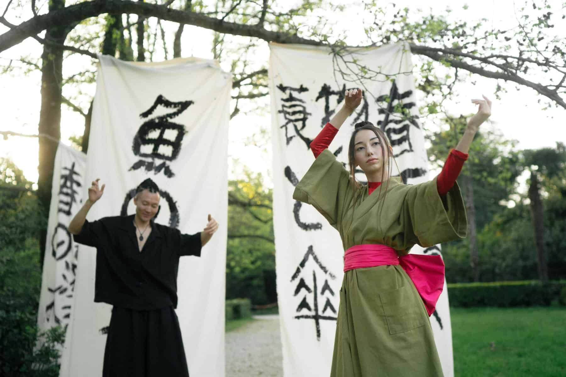 Home Icy 40 Woman performing traditional Japanese dance outdoors with banners in background.