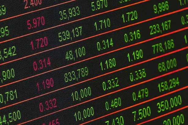 Stock market ticker showing green and red numbers representing stock prices and changes.