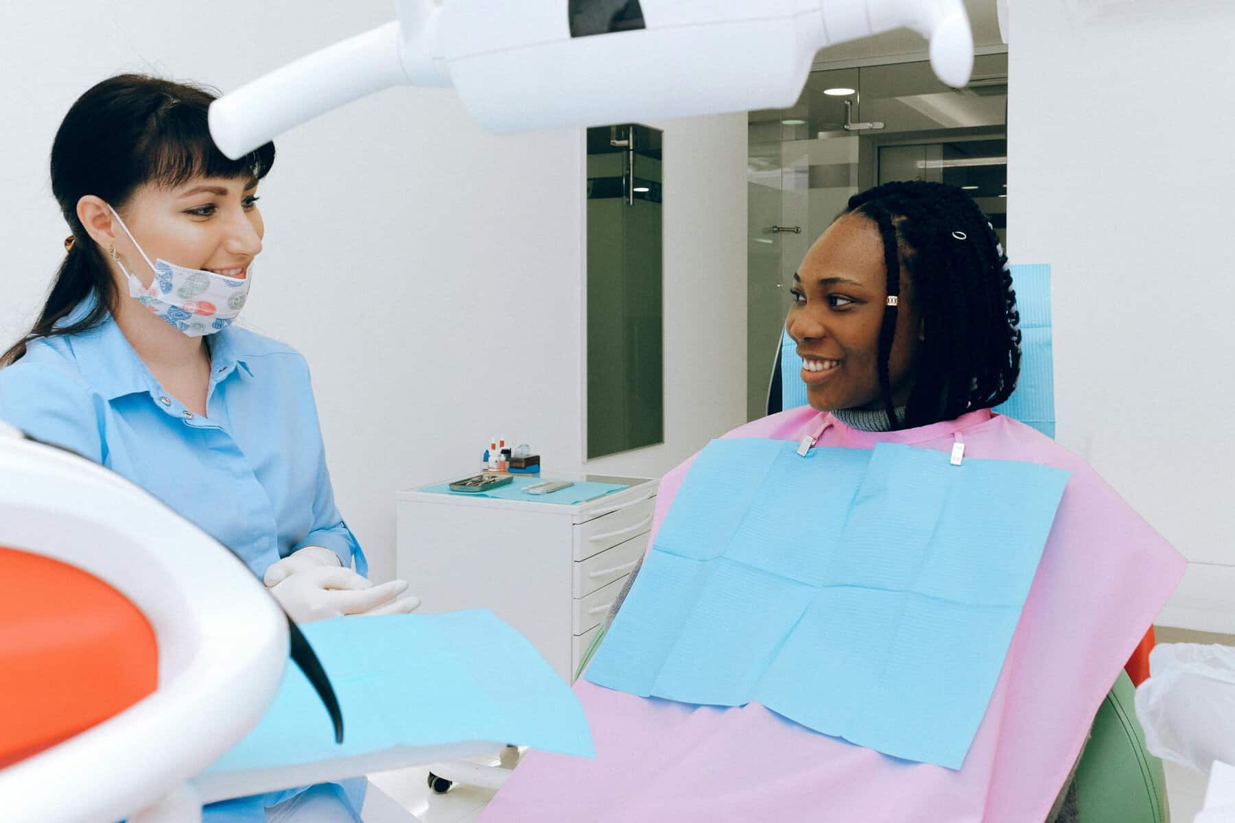 Dental checkup with dentist and patient in clinic, smiling during examination.