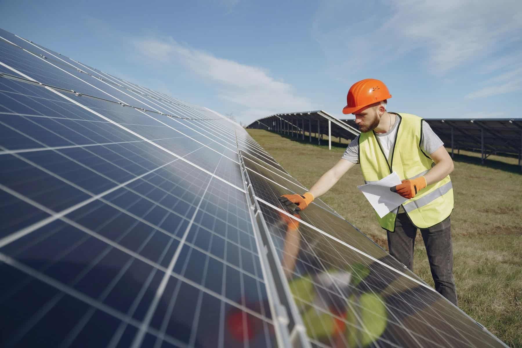 Home Icy 46 Technician inspecting solar panels at a renewable energy site.