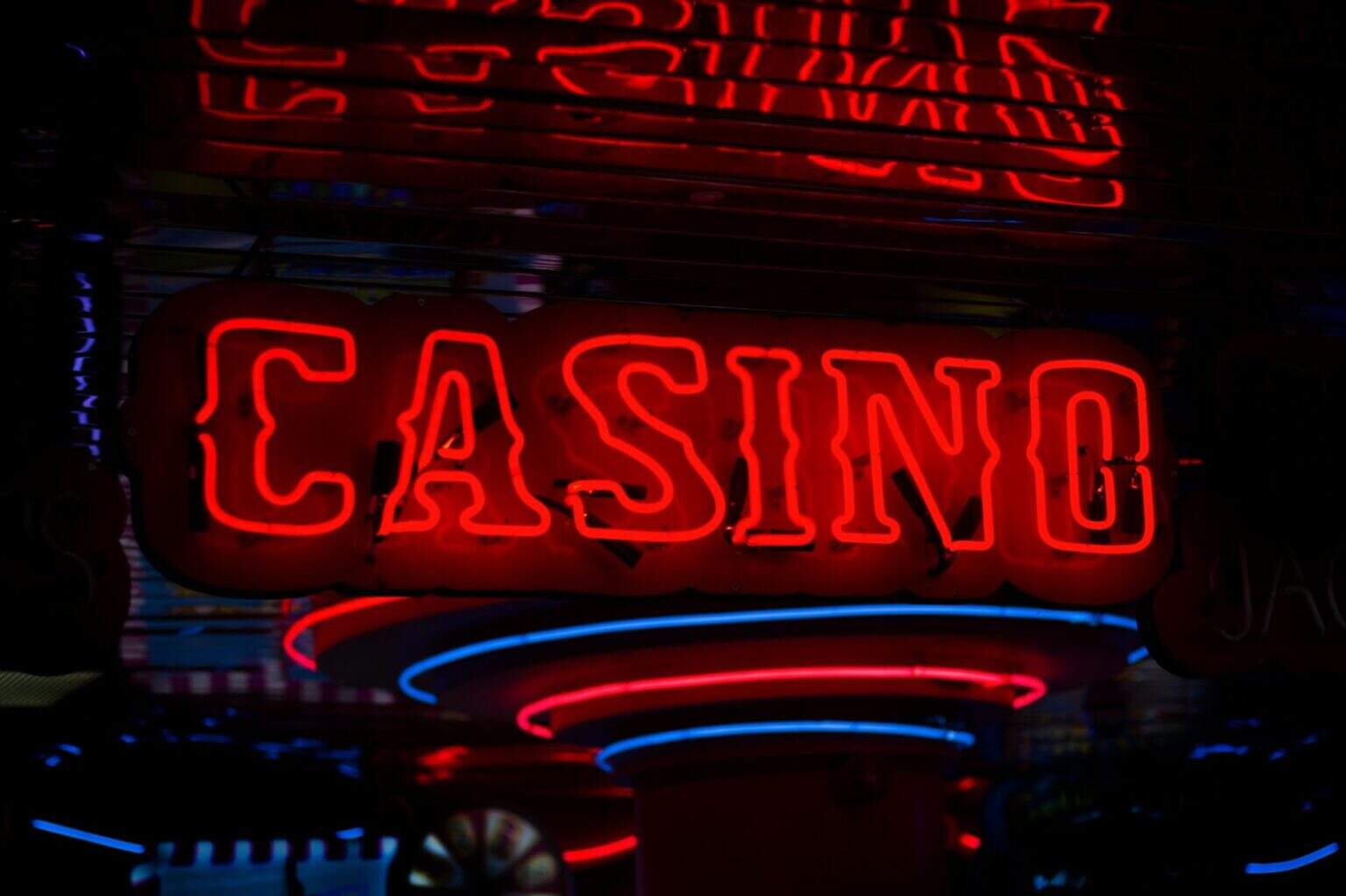 Neon casino sign illuminated at night with vibrant red and blue neon lights.