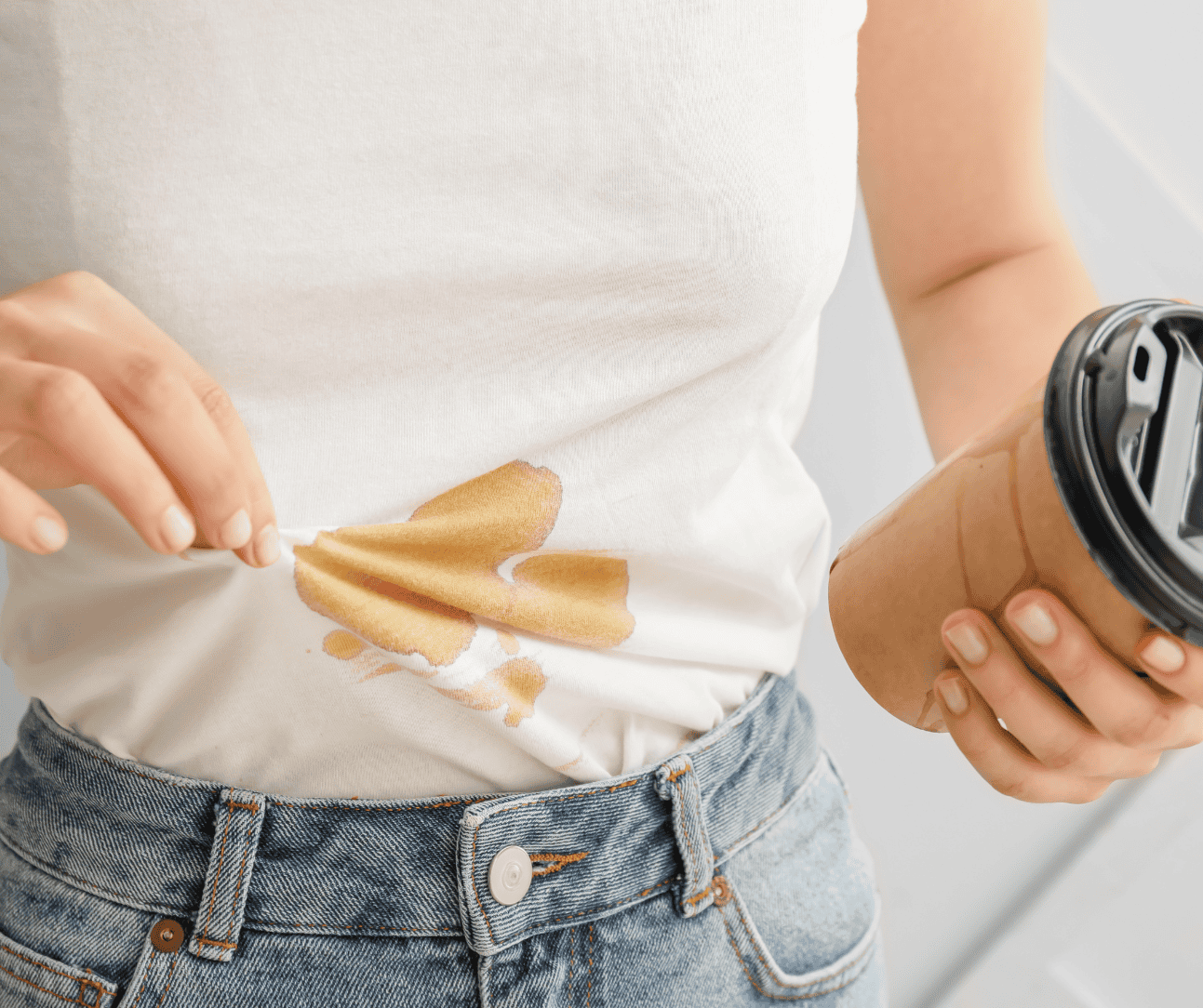 Home Icy 43 Stain of coffee on casual white T-shirt, with person holding a takeaway coffee cup.