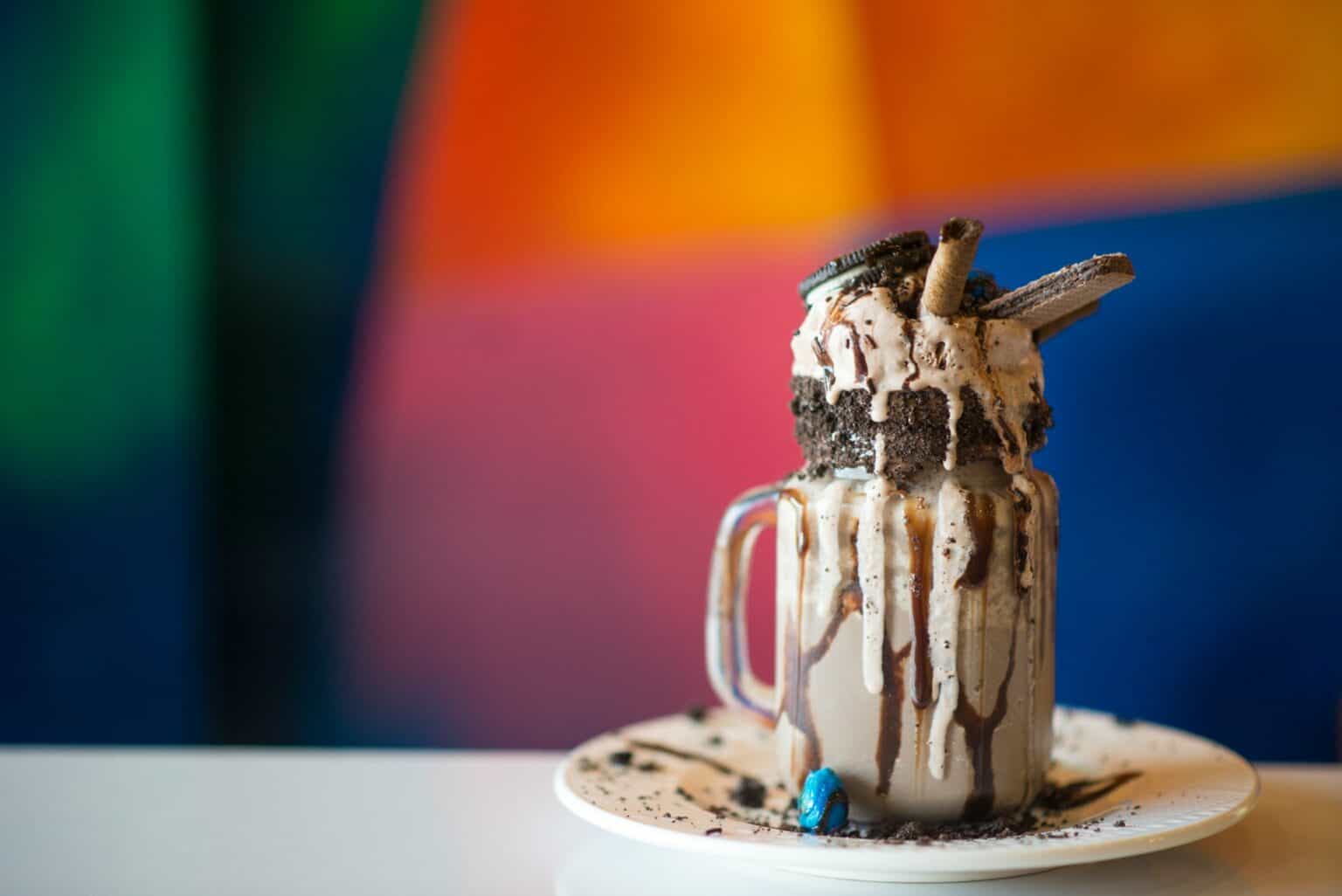Rich Oreo milkshake topped with cookies, chocolate syrup, and whipped cream, served in a mason jar.