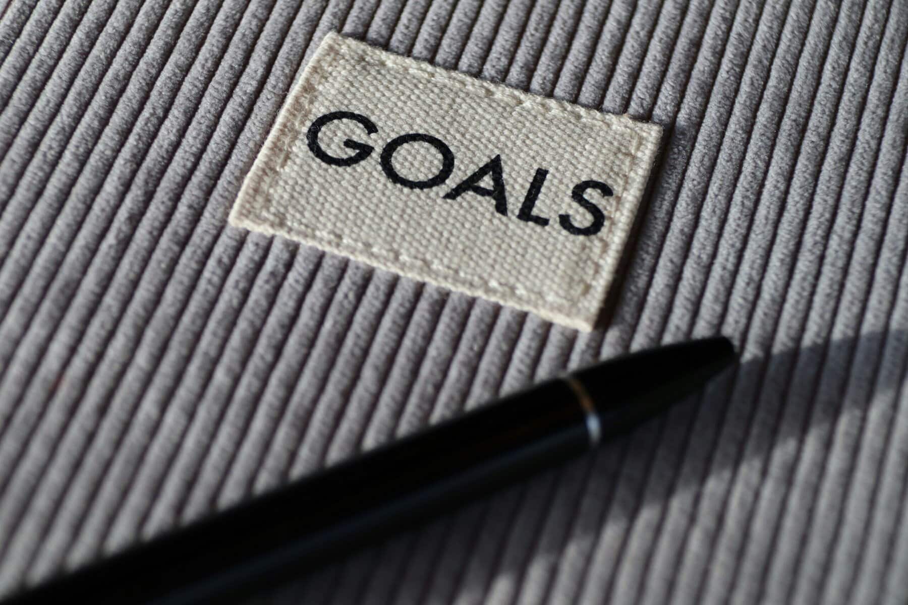 Close-up of goal-setting patch on striped fabric with black pen.