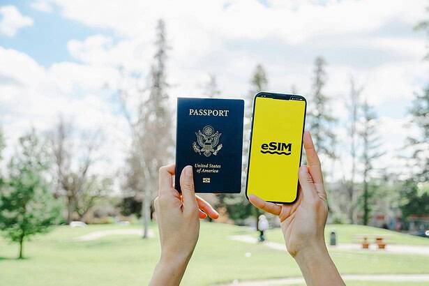 US passport and eSIM on phone for international travel in outdoor park setting.