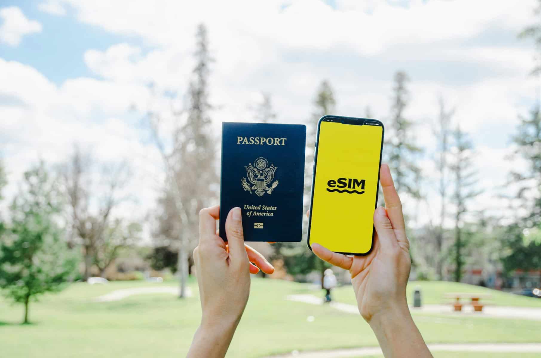 Home Icy 40 US passport and eSIM on phone for international travel in outdoor park setting.