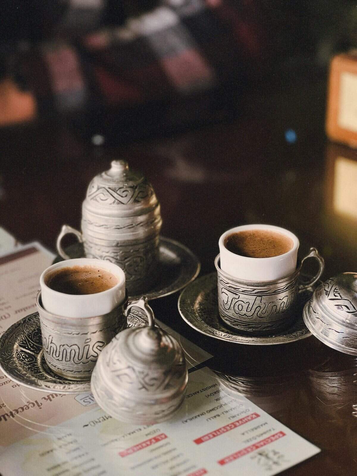 Intricate silver tea cups and pots serving traditional coffee or tea.
