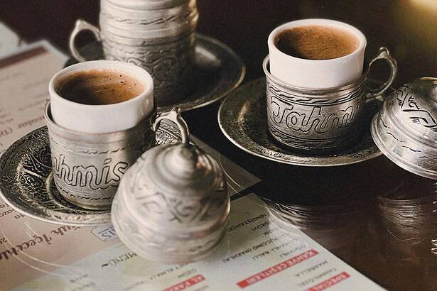 Intricate silver tea cups and pots serving traditional coffee or tea.