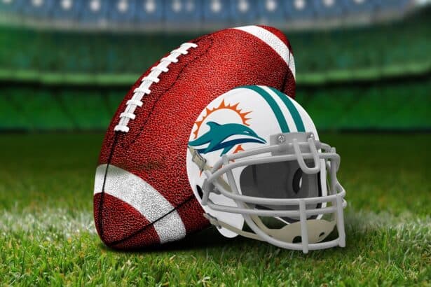 Close-up of American football ball with Miami Dolphins helmet on lush green field.